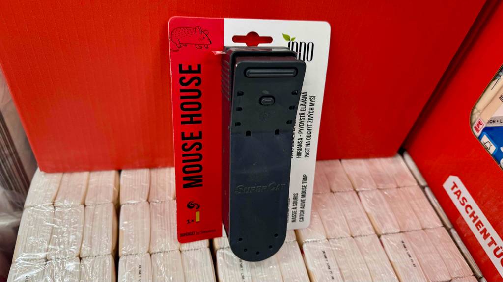 Eine im Kartonblister verpackte Mausefalle-Schlagfalle steht zum testen auf Taschentüchern.