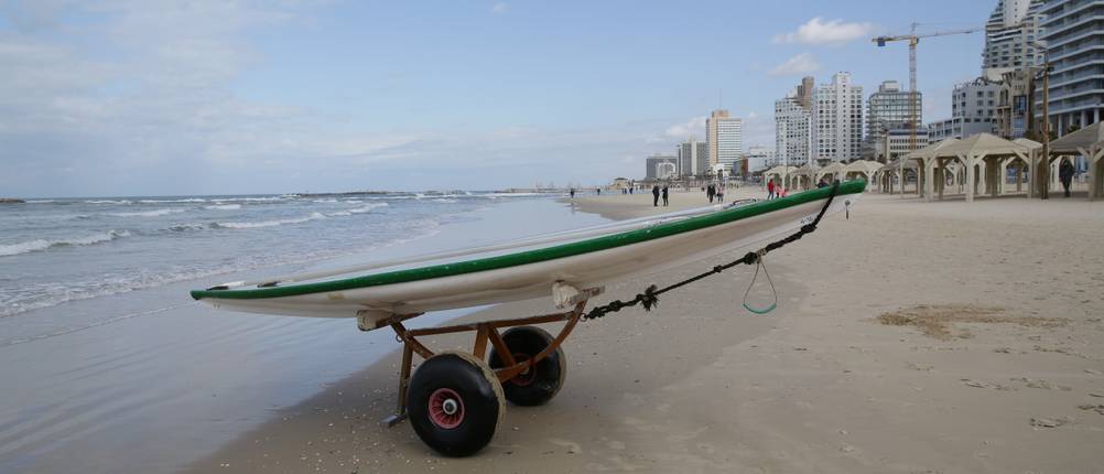 Surfwagen-Test: Ein Surfwagen mit einem Kanu steht am Strand. 