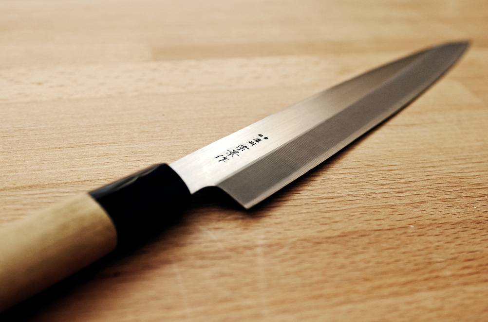 Sushimatte-Test: Ein Sushimesser mit Holzgriff liegt auf einer Holzfläche. 