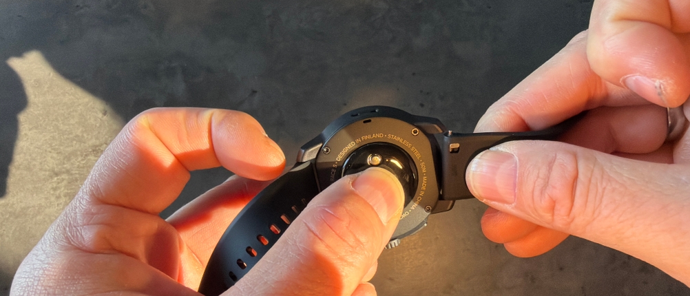 Ein Finger drückt auf die Unterseite der Suunto Race S