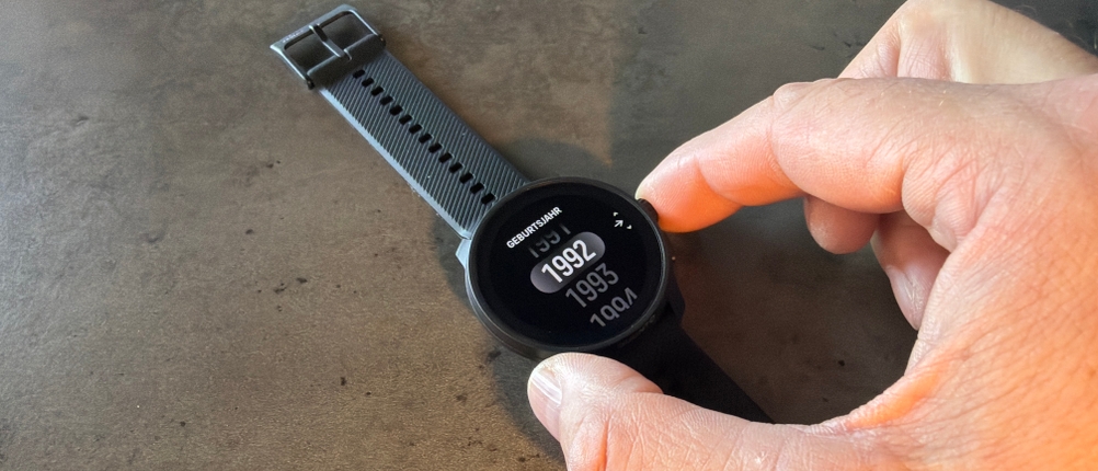 Eine Hand stellt das Geburtsjahr auf der Suunto Race S ein