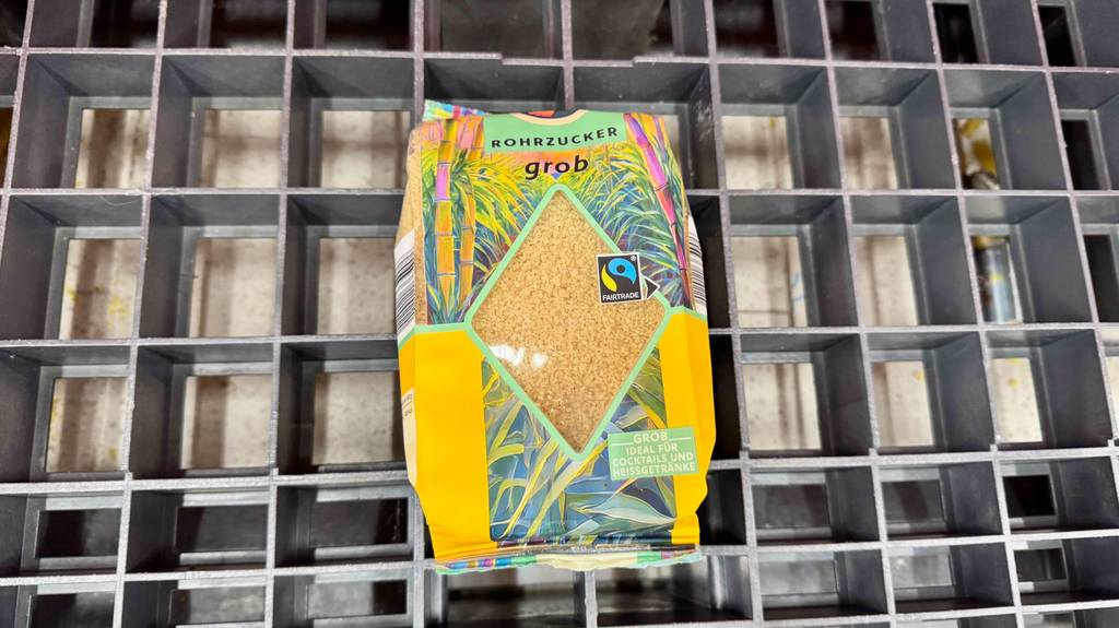 Eine Packung Rohrohrzucker liegt zum Testen auf einem Gitter.
