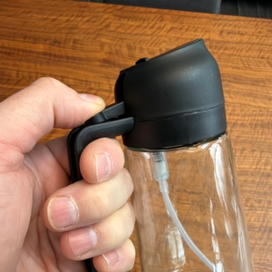 Eine Hand drückt auf den Hebel am Sweet-View-2-in-1-Ölsprüher