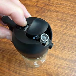 Eine Hand drückt einen Schieber auf dem Sweet-View-2-in-1-Ölsprüher