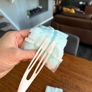 Eine Hand zieht den Swiffer-Staubwedel auf den Griff.