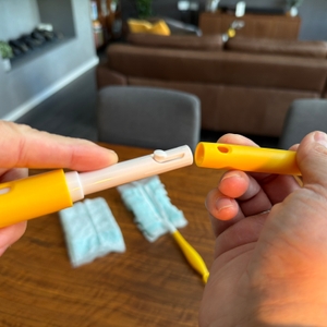 Eine Hand steckt den Griff vom Swiffer-Staubwedel zusammen.