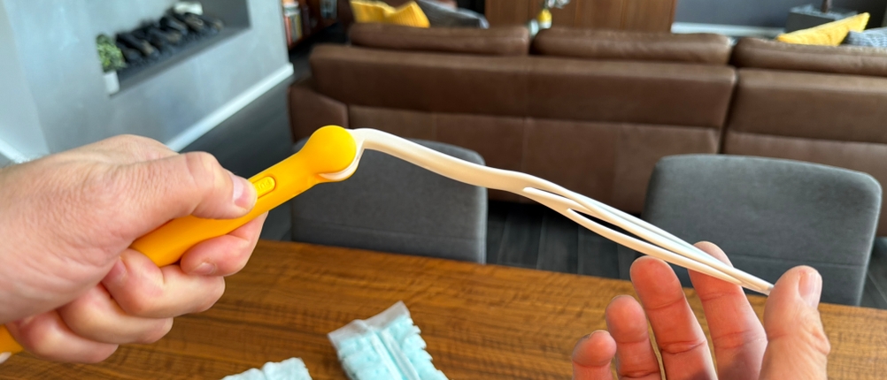 Eine Hand knickt den Swiffer-Staubwedel.