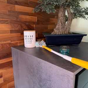 Mit dem Swiffer-Staubwedel wird ein Schrank gereinigt.