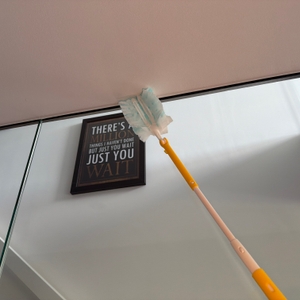 Mit dem Swiffer-Staubwedel wird eine Glasscheibe gereinigt.