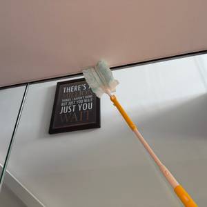 Mit dem Swiffer-Staubwedel wird eine Glasscheibe gereinigt.