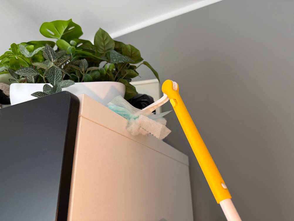 Mit dem Swiffer-Staubwedel wird ein Schrank von oben gereinigt.