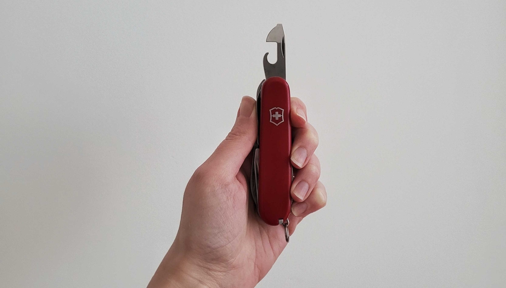 Ansicht auf das Flaschenöffner-Instrument eines getesteten Schweizer Taschenmessers, das von einer Hand gehalten wird.