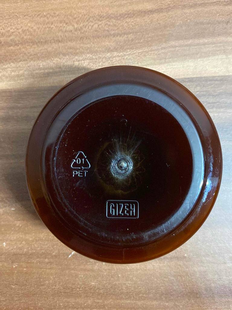 Haarwachs getestet: ein Glastiegel steht auf dem Kopf auf einer Holzfläche.