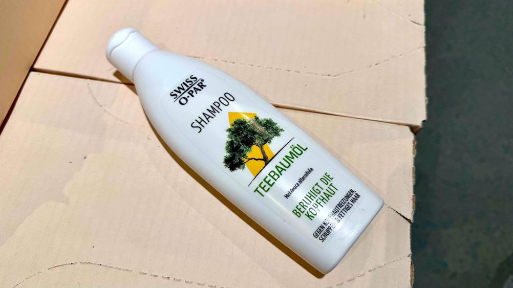 Auf einem Karton liegt eine Flasche des Swiss-o-Par-Shampoos im Test.