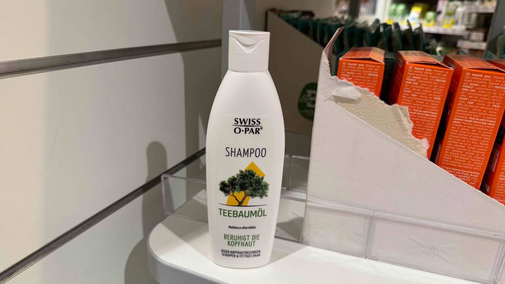 Swiss-o-Par-Shampoo im Test: eine Flasche auf einer hellen Oberfläche, im Hintergrund Produkte.