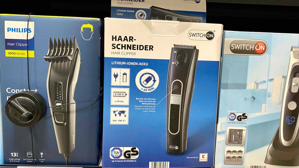 Mehrere getestete Akku-Haarschneider in Verpackungen unterschiedlicher Marken stehen im Verkaufsregal.