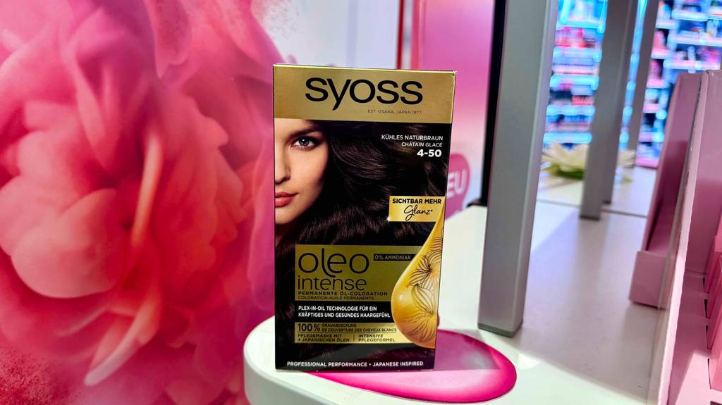 Eine Packung braune Haarfarbe steht zum testen auf einem weißen Regal mit rosa Herz.