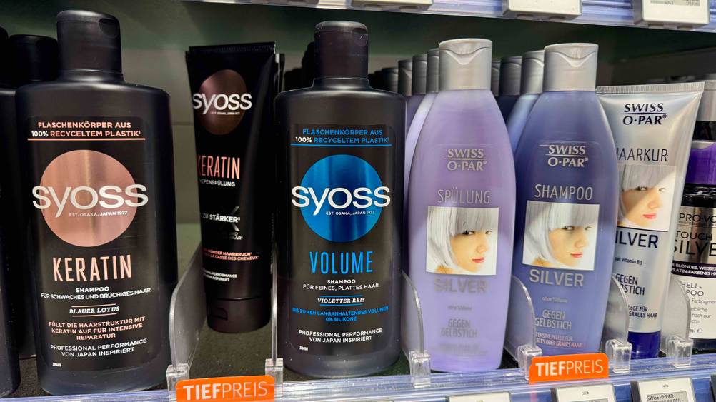 Syoss-Shampoo getestet: Mehrere Flaschen in einem Regal neben anderen Produkten.