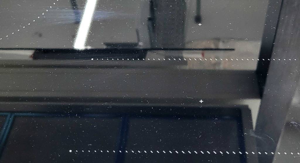 Neff-Induktionskochfelder-Test: Nahaufnahme des Plus-Zeichens auf einem schwarzen Induktionskochfeld.