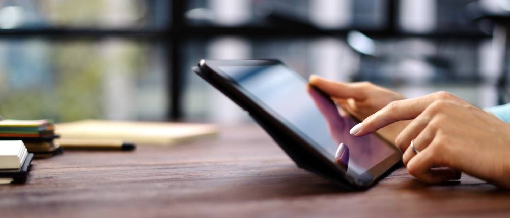 Tablet-10-Zoll-Test: Eine Frau bedient ein Tablet an einem Schreibtisch. Man sieht nur ihre Hände. 