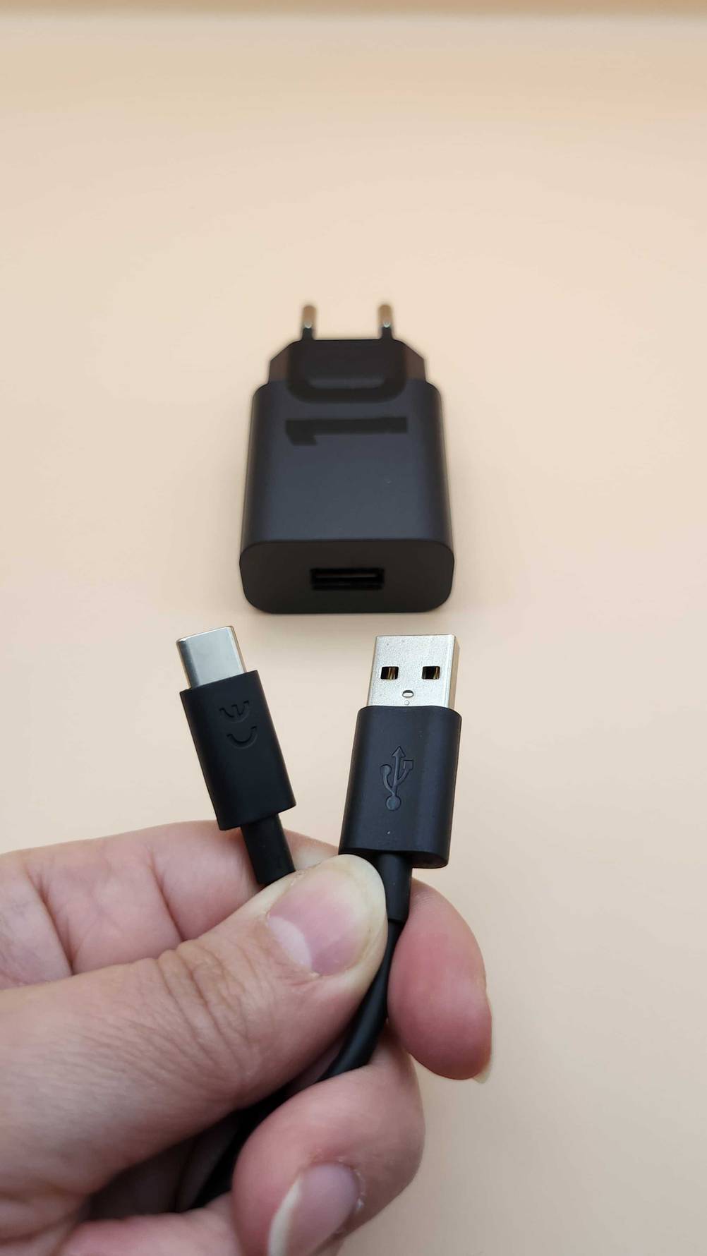 Tablet LTE getestet: Eine Hand hält ein USB-Kabel im Hintergrund der Stromstecker.