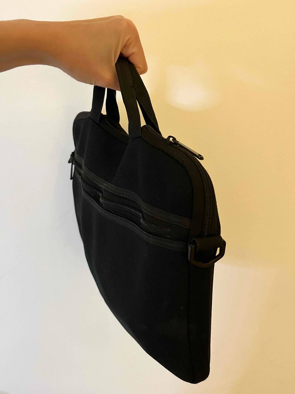 In der Hand befindet sich eine getestete Tablet-Tasche mit Griff.