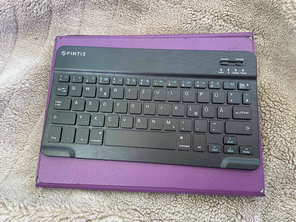 Tablet-Tastatur mit Unterlage auf einer Decke.