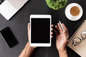 Tablet-Versicherungen im Test: Eine Person hält ein weißes Tablet und einen Stift in den Händen