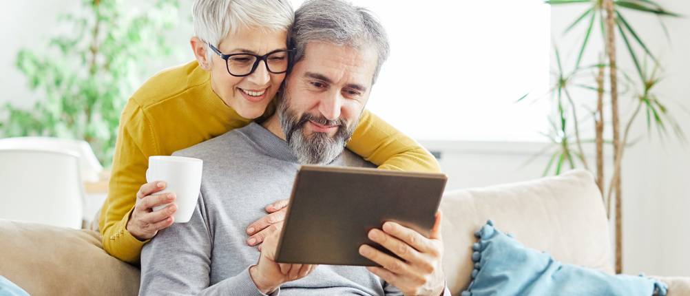 Tablet-Versicherungen im Test: Ein älteres Ehepaar schaut gemeinsam auf ein Tablet.