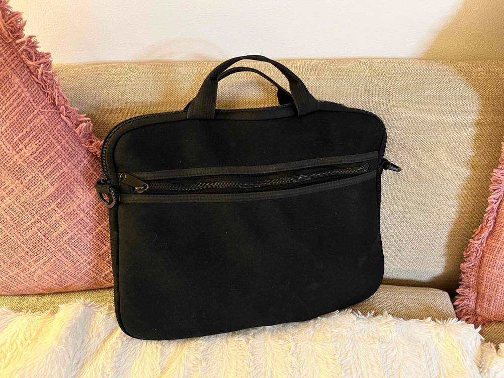 Im Test: schwarze Tablet-Tasche mit Tragegriff steht auf Couch.