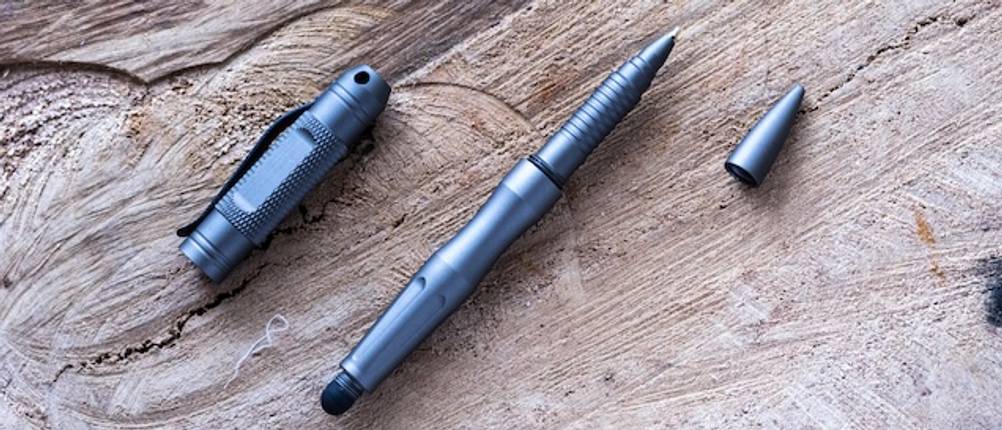 Getesteter Tactical Pen in Blau liegt auf einem Untergrund aus Holz.
