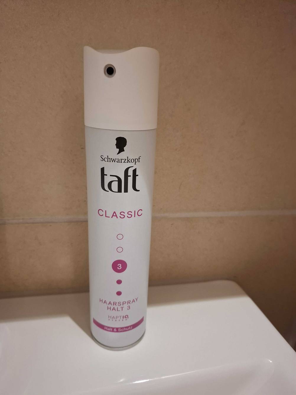 Eine Dose des getesteten Taft-Haarsprays vor einer hellen Fließenwand.
