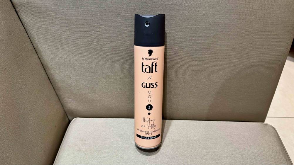Getestet: Eine Dose des Taft-Haarsprays auf einem beigen Polstermöbel.