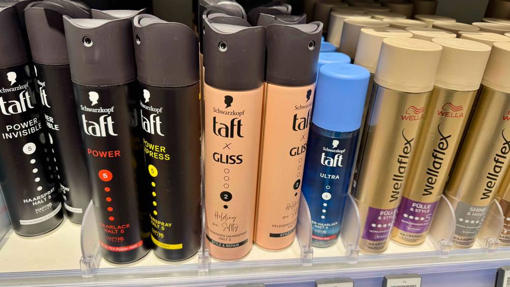 Im Verkaufsregal stehen mehrere Dosen des Taft-Haarsprays im Test neben anderen Produkten.