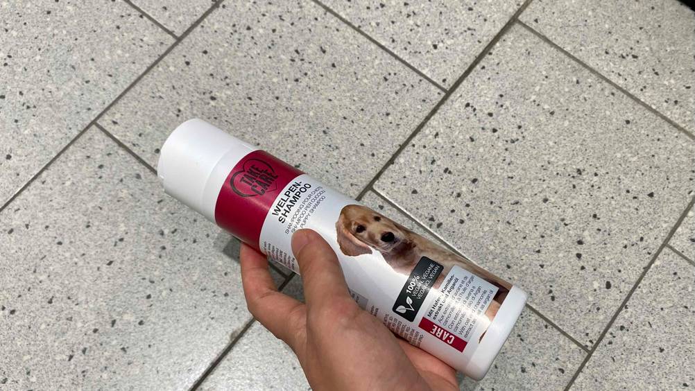Getestetes Welpen-Shampoo von Take-Care wird in der Hand gehalten.