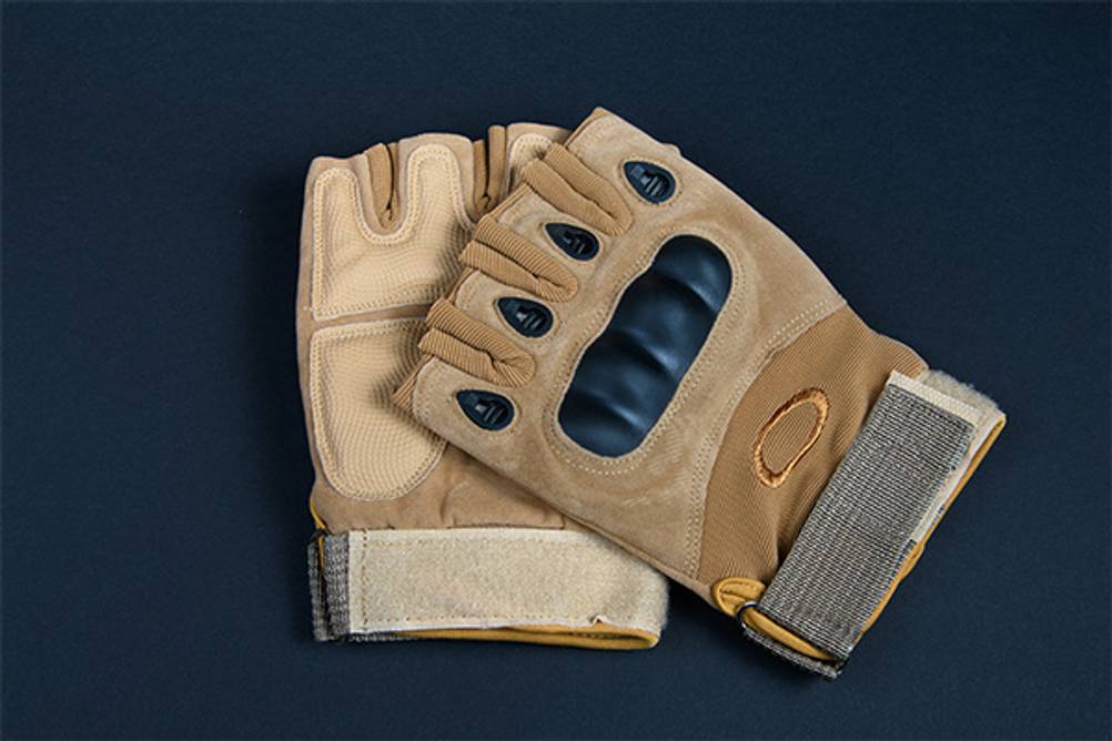 Taktische Handschuhe im Test: Ein paar fingerlose taktische Handschuhe auf dunkler Oberfläche.