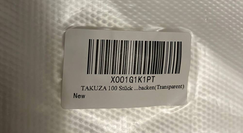 Nahaufnahme der Verpackung mit Produktetikett (100 Stück Takuza) von transparenten Einmal-Spritzbeuteln im Test.