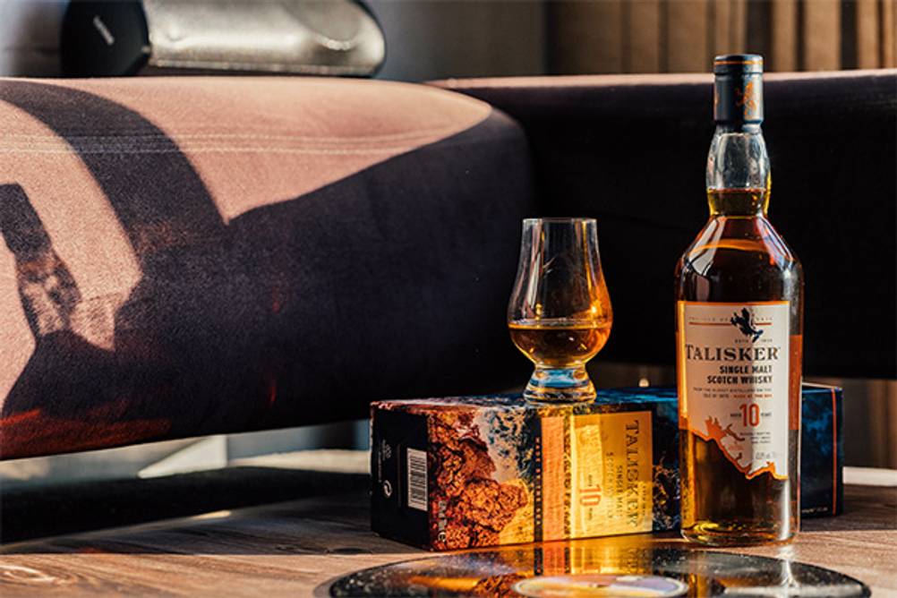 Talisker im Test: Eine Couch, vor der eine Flasche Talisker 10 Years Old sowie ein Glas stehen.