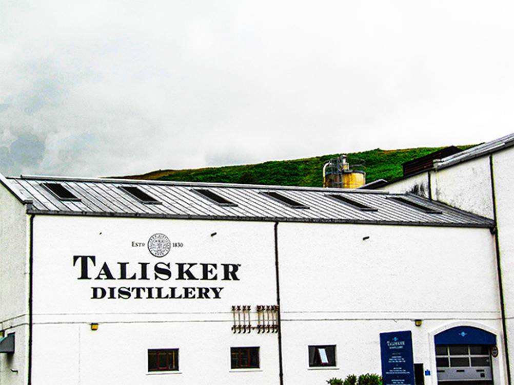 Talisker im Test: Ein Blick auf die weiße Fassade der Brennerei mit der Aufschrift Talsiker Distillery.
