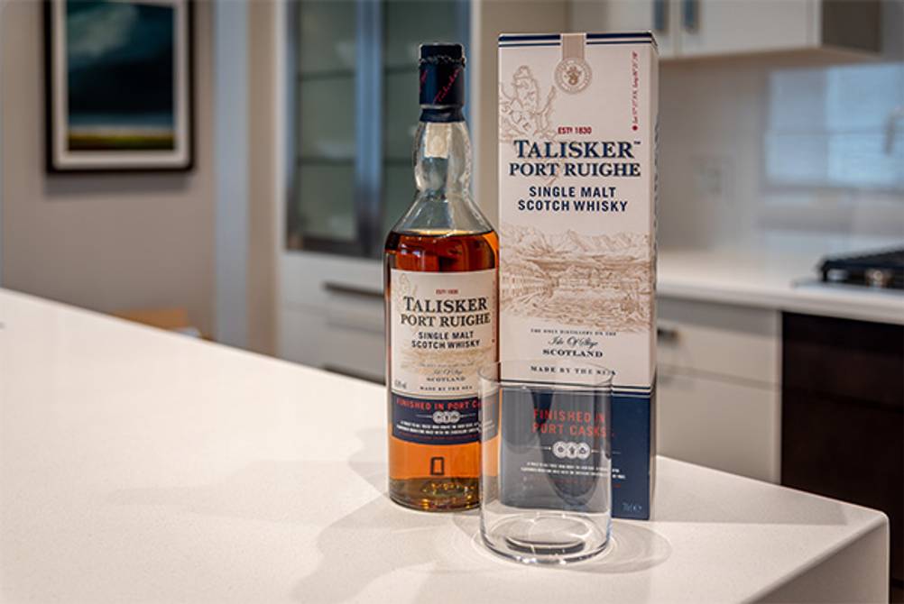 Talisker im Test: Hier eine Flasche Port-Ruighe-Single-Malt-Scotch-Whisky mit Glas und Geschenkverpackung auf einem Küchentresen.