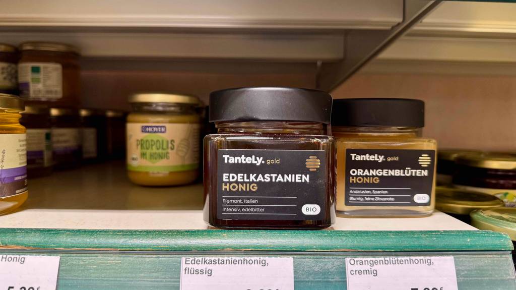 Kastanienhonig getestet: Mehrere Gläser mit braunem Inhalt stehen auf einem Verkaufsregal mit unterschiedlichen Honigsorten.