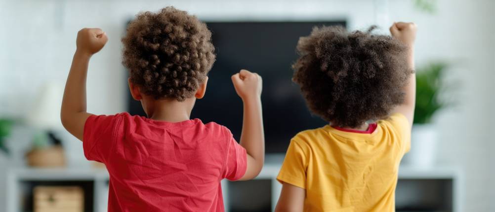 Tanzmatte getestet: Zwei Kinder bewegen sich vor einem Fernseher.
