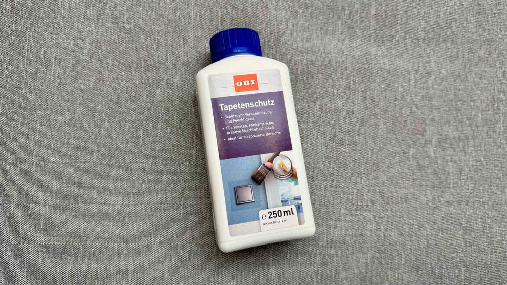 Auf einem grauen Stoff liegt der Tapetenschutz im Test.