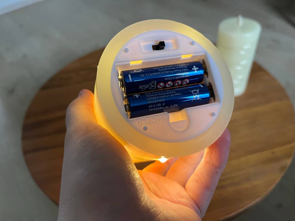 eine LED-Kerze von unten mit zwei Akkus in den Vorrichtungen dafür