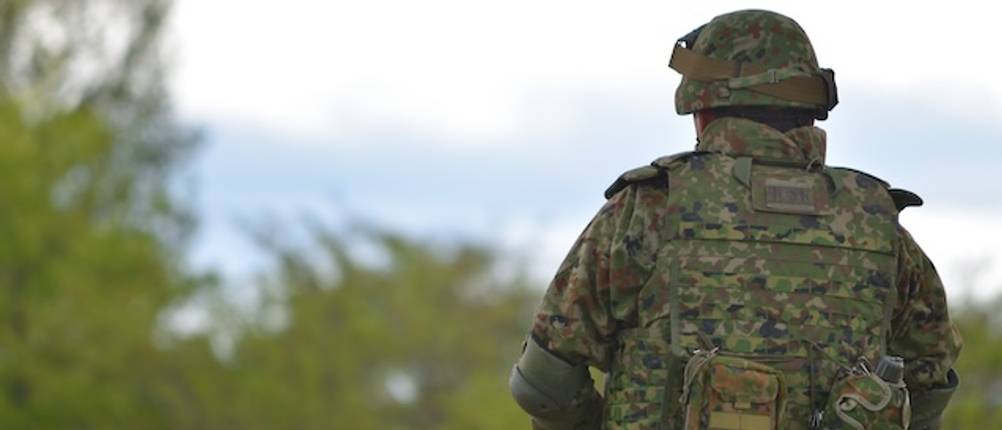 Tarnanzug im Test: Ein Soldat im Tarnanzu von hinten vor einem Hintergrund mit Wald.