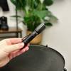 Die Nextorch TA30C Taschenlampe wird in einer Hand gehalten. Das kompakte Design mit Clip ist sichtbar.
