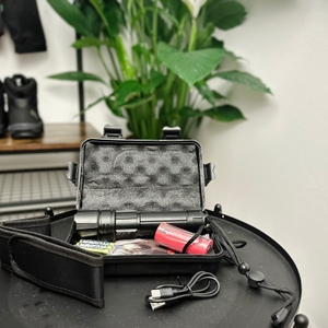 Der Lieferumfang der Shadowhawk S1476 ist in einem offenen Transportkoffer zu sehen. Neben der Lampe sind ein Akku, ein Ladegerät und weiteres Zubehör enthalten.