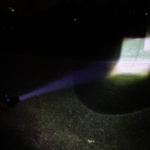 Die Shadowhawk S1476 projiziert ihr Licht auf den Boden, wobei ein deutliches Schattenkreuz sichtbar ist. Die Beleuchtung hat eine quadratische Form mit dunklen Linien im Lichtkegel.