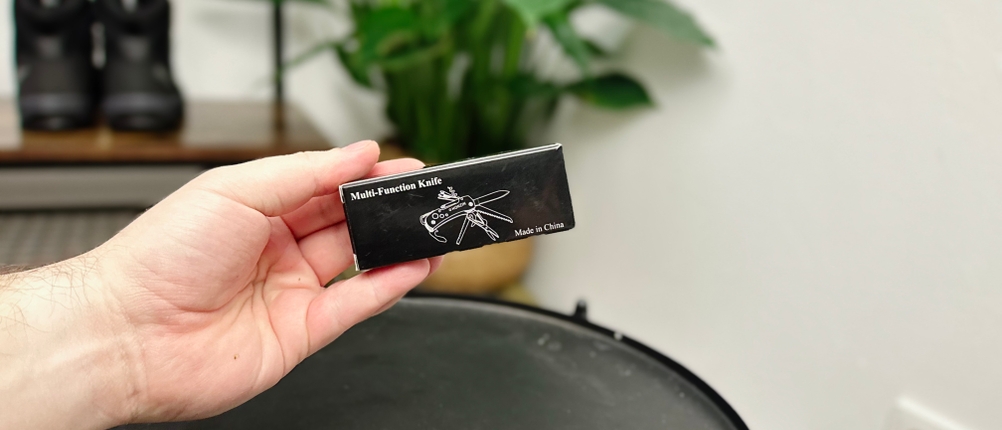 Die Verpackung des Honzin Taschenmesser HJ-011 zeigt ein schlichtes Design mit schwarzem Hintergrund. Auf der Vorderseite ist ein gezeichnetes Messer abgebildet.