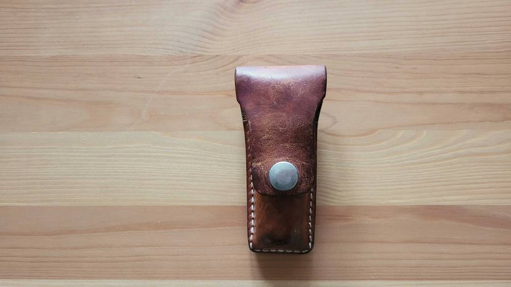 Taschenmesser-Test: Ein Ledercase für das Messer auf einer Holzoberfläche.